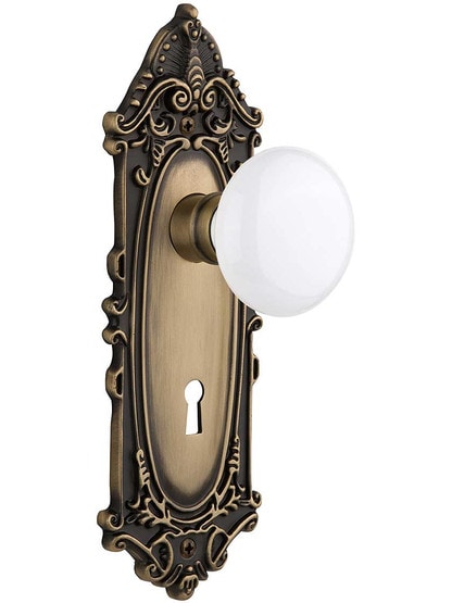 Largo Door Set with White Porcelain Knobs and Keyhole Single Dummy in Antique Brass.